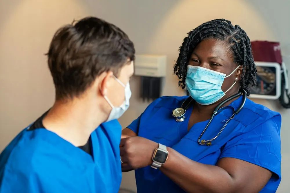 Nurse in blue scrubs caring for a patient