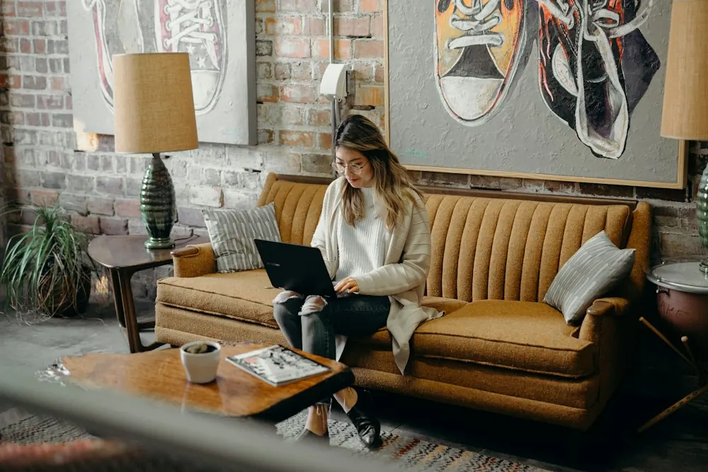 Woman working on her laptop from a sofa at home